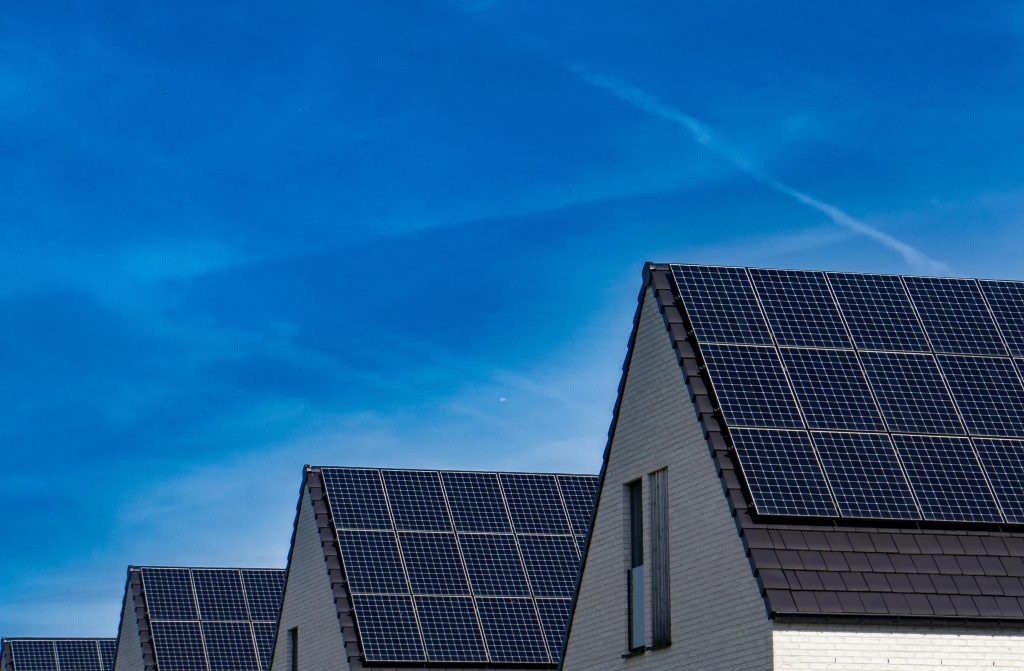 Row of roofs with solar panels on them.